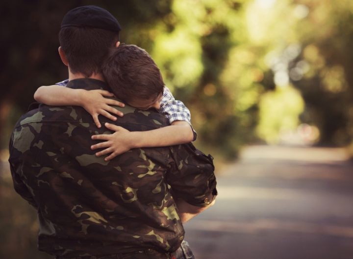 boy hugging dad in army uniform