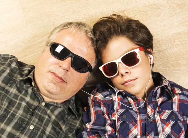 dad and son lying on floor wearing sunglasses, headphones